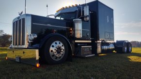 A custom black semi-truck with a large sleeper on back.