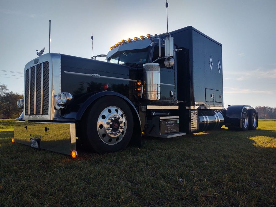 A custom black semi-truck with a large sleeper on back.