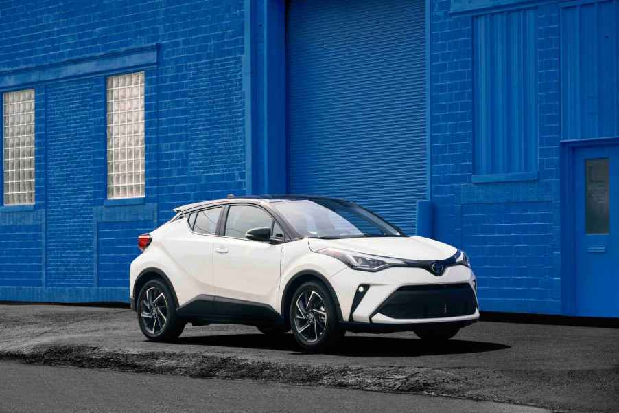 A white 2022 Toyota C-HR in front of a bright blue wall.