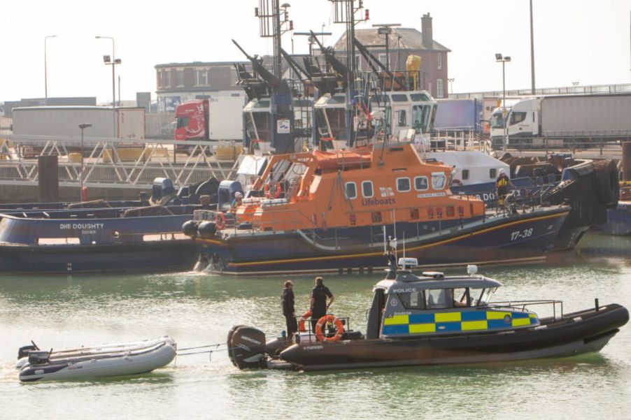 Two smaller inflatable boats being towed in a channel by a larger boat.