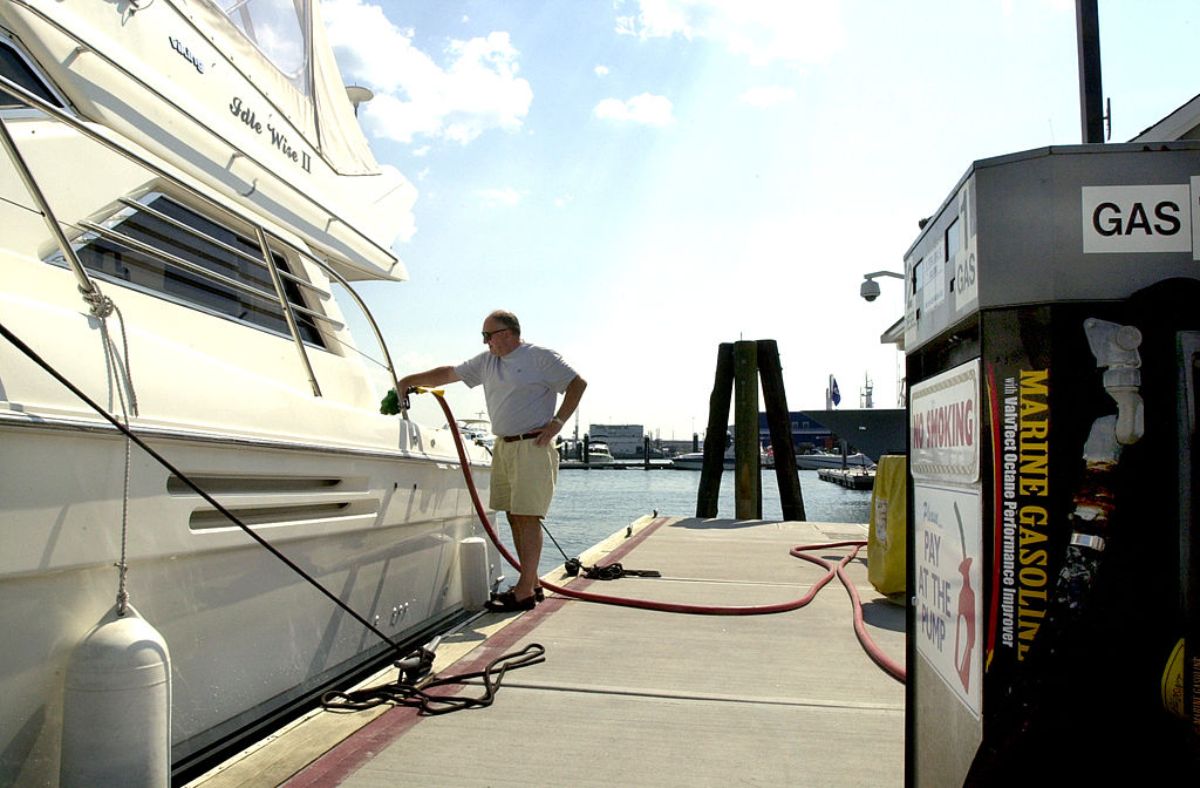 A man fueling up his Viking Yacht at a gas station.