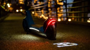 A Costco Bugatti scooter showing its taillights at night.