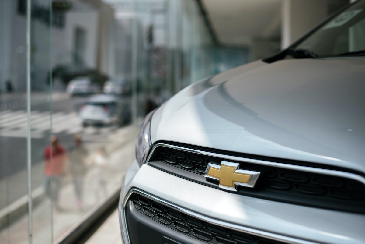 A close up of the Chevy logo on a car at a dealership.