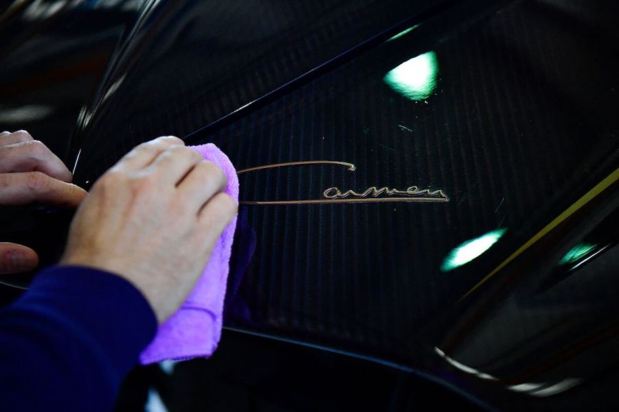 A man uses a towel to clean a car