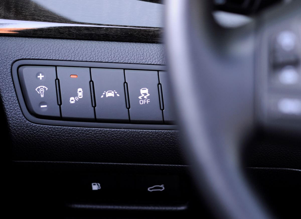 Driver assistance buttons next to the steering wheel, including Lane Departure Warning, in a 2014 Kia Cadenza