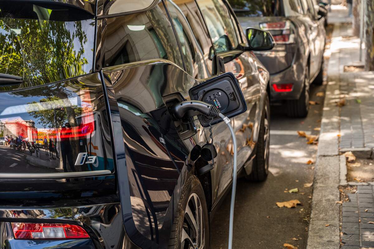 An electric car charges on the side of the road