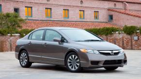 A 2011 Honda Civic EX-L compact sedan model parked in an empty lot outside of a red brick villa