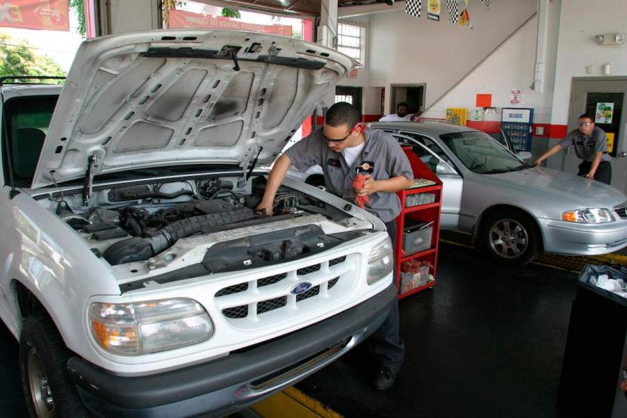 A mechanic performs an oil change service in a Ford vehicle at Jiffy Lube