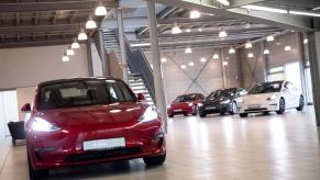 A red Tesla Model 3 vwith other Tesla models in the background at the Tesla Service Center in Hamburg, Germany