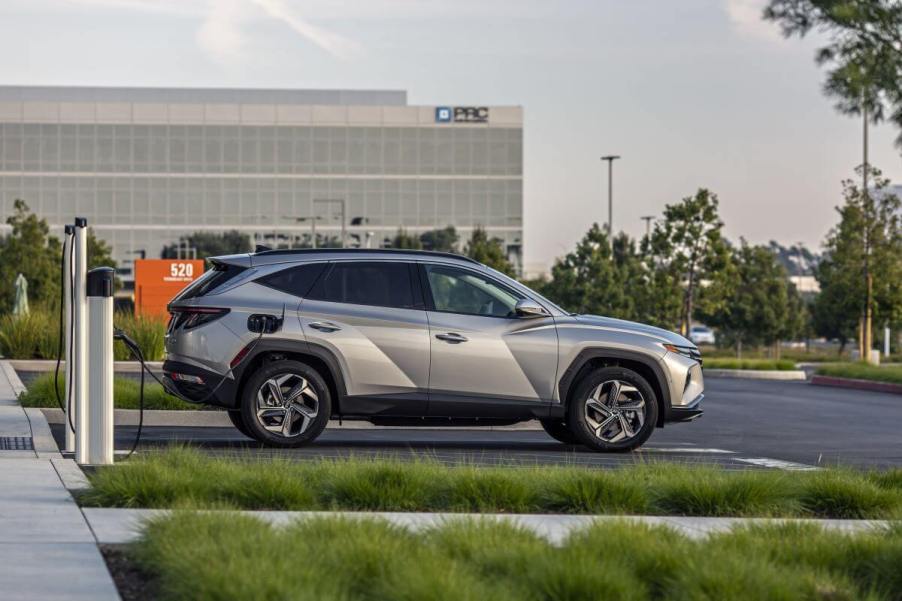 A side profile shot of a 2023 Hyundai Tucson Plug-In Hybrid compact SUV model parked into an EV charging station