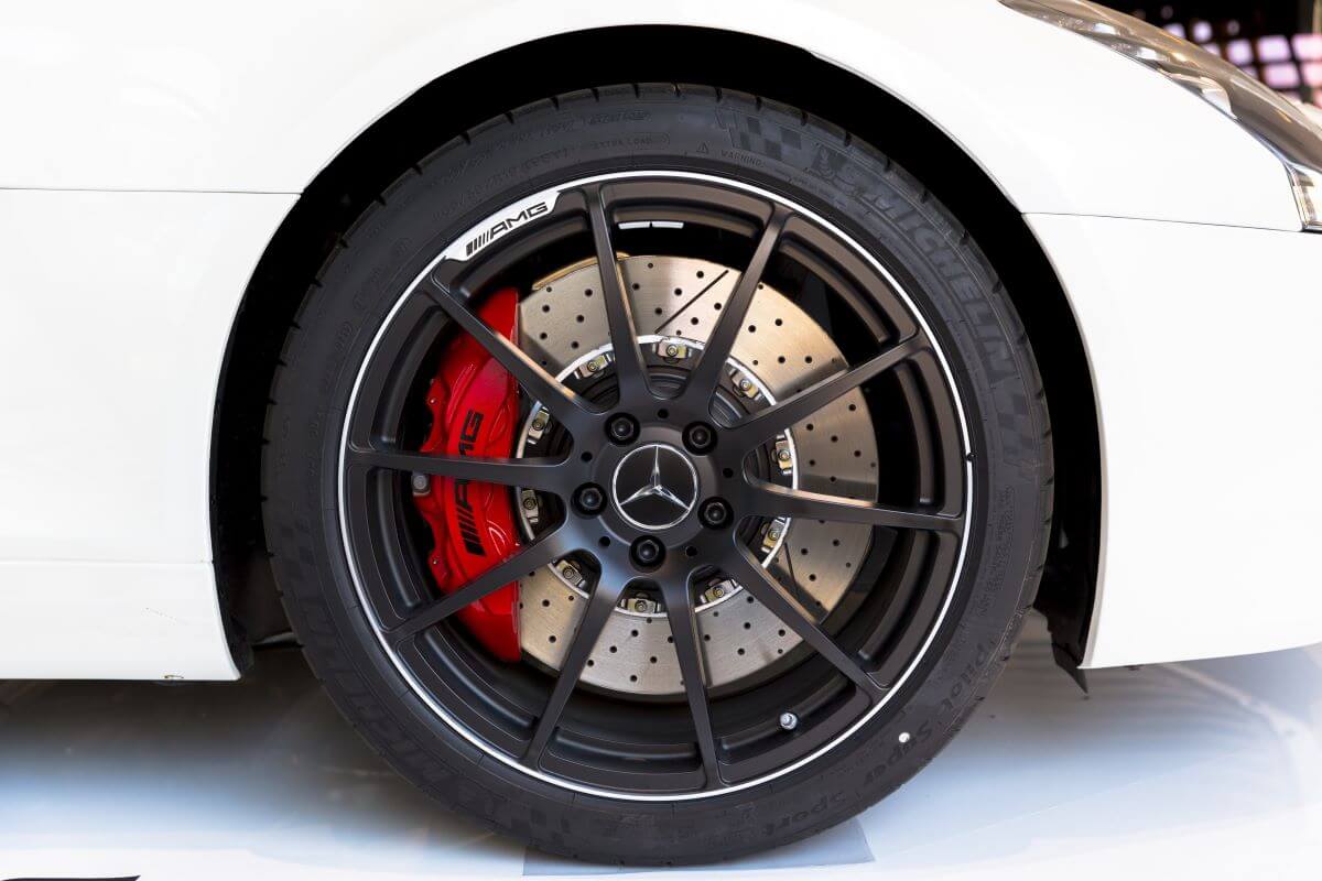 The wheel and ventilated disc brakes of a Mercedes AMG SLS 6.3 with red brake calipers