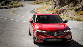 Red 2023 Acura Integra parked off of a curvy and winding road.