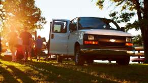 People exit a white 2016 Chevy Express passenger van