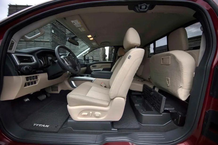 Closeup of a Nissan Titan King Cab pickup truck with its front doors and rear-hinged rear doors all open.