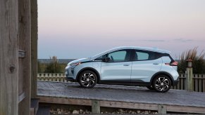 A used Chevrolet Bolt EV shows off its electric hatchback car profile on the beach.