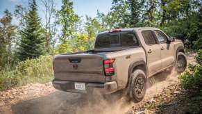 A tan Nissan Frontier driving off-road.