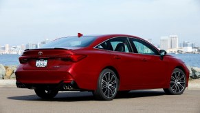 A 2022 Toyota Avalon shows off its rear-end styling next to a harbor.