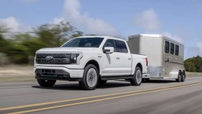 The 2023 Ford F-150 Lightning towing a trailer on the road