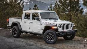 The 2023 Jeep Gladiator parked near trees on a mountain road