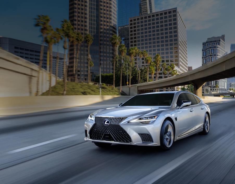 A 2023 Lexus LS 500h driving down a road.