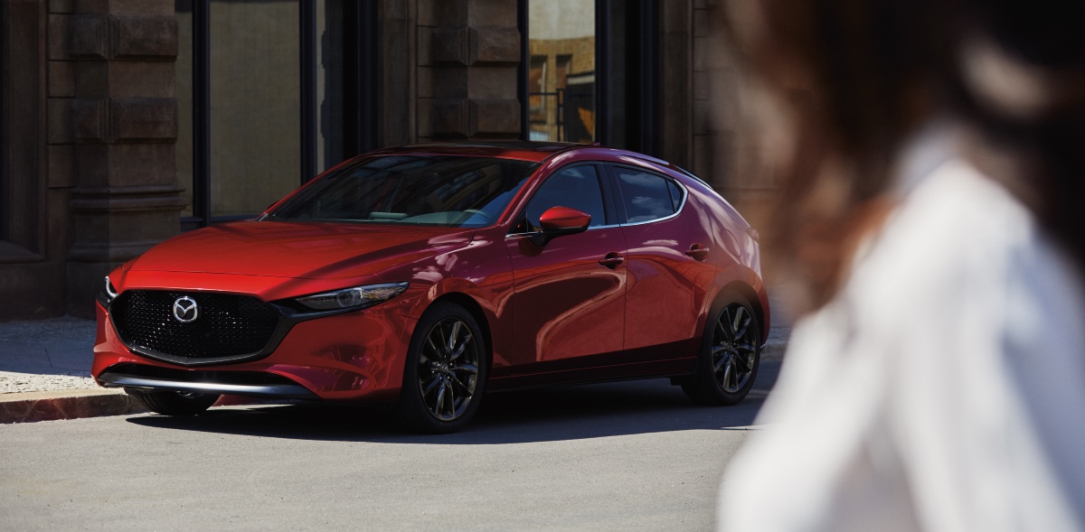 A red 2023 Mazda3 hatchback parked