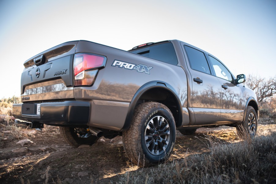 A dark brown 2023 Nissan Titan driving up rocks