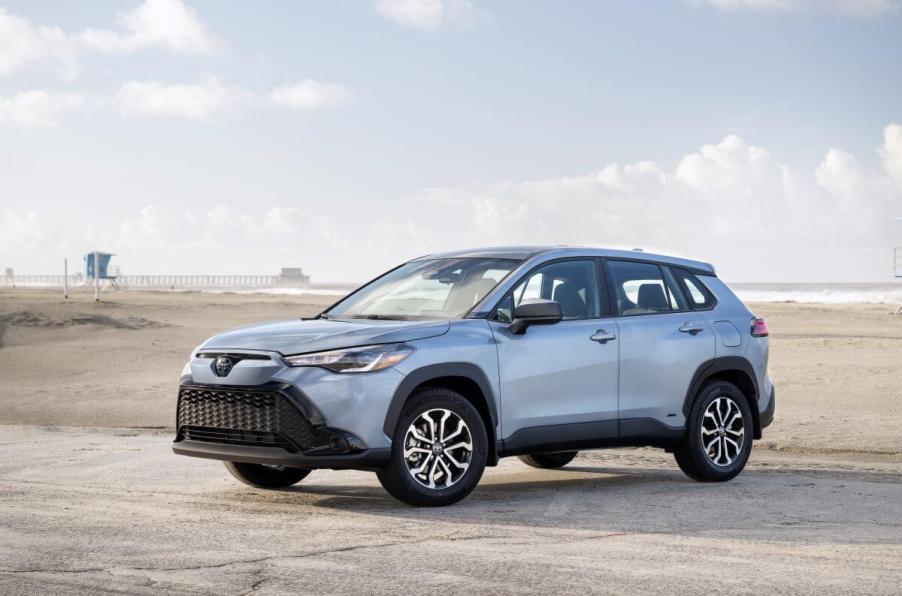 A 2023 Toyota Corolla Cross Hybrid in Celestite Gray color option parked on a sandy beach