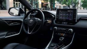 The driver's seat, driver's display, transmission, and infotainment touchscreen inside a 2023 Toyota RAV4 Prime