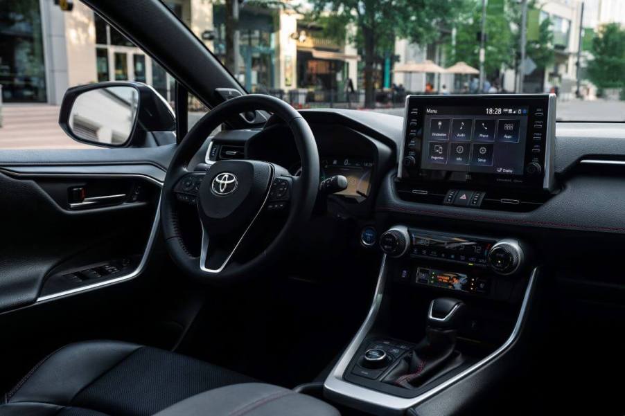 The driver's seat, driver's display, transmission, and infotainment touchscreen inside a 2023 Toyota RAV4 Prime