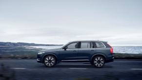 A side profile shot of a 2023 Volvo XC90 Recharge T8 AWD plug-in hybrid midsize luxury SUV in Denim Blue