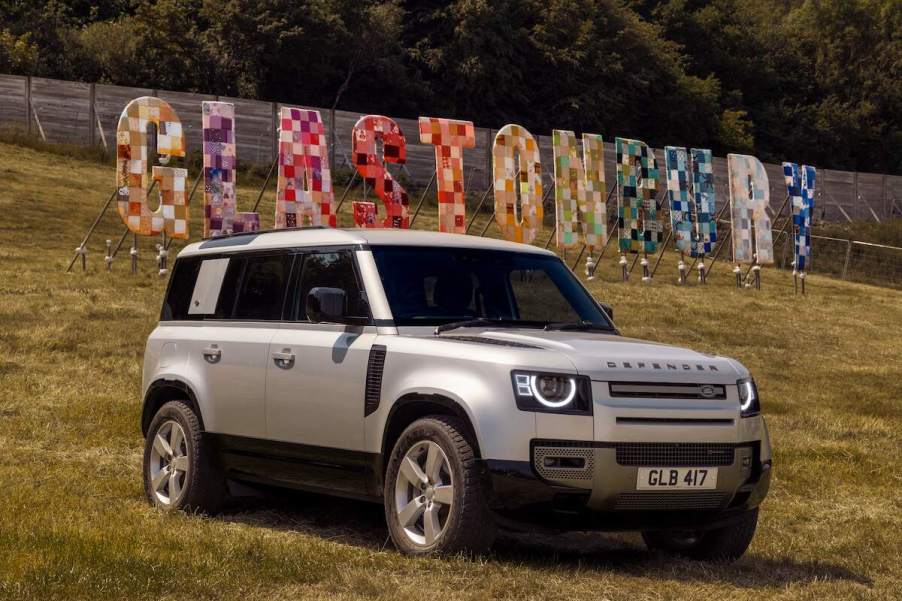 A 2024 Land Rover Defender luxury SUV parked on a hill at the 2023 Glastonbury Festival