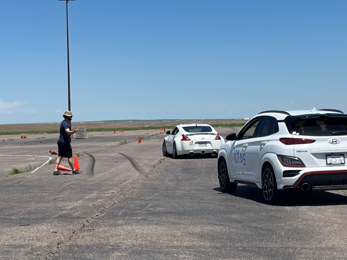 A white Hyundai Kona and Nissan at the starting line of an autocross racing event