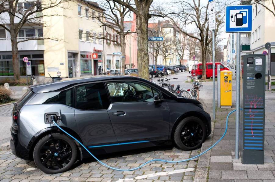 A BMW i3 electric car being charged at a charging station on a street in Bavaria, Forstinning, Germany