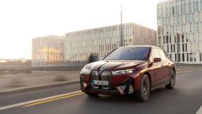 A BMW iX M60 midsize electric luxury SUV model in Aventurin Red Metallic