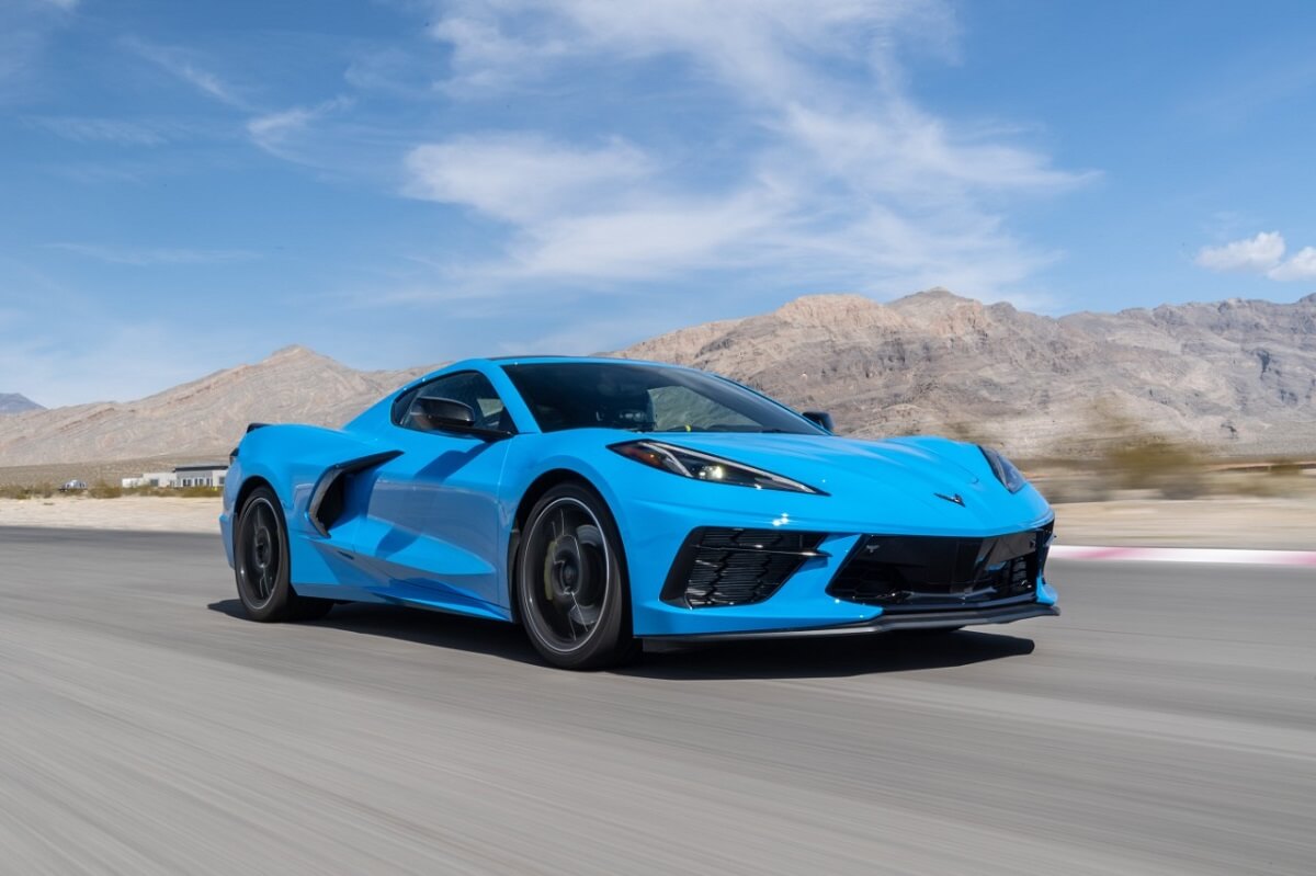 A blue Chevrolet Corvette C8 Stingray sports car drives on Willow Springs Raceway.