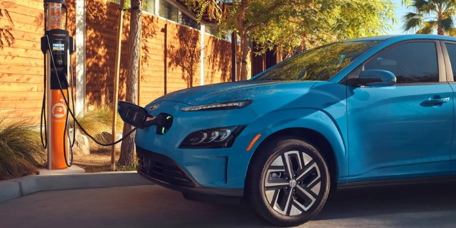 A blue 2023 Hyundai Kona Electric is charging.