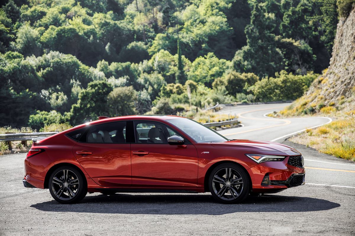 A red Acura Integra side profile with a winding road behind it