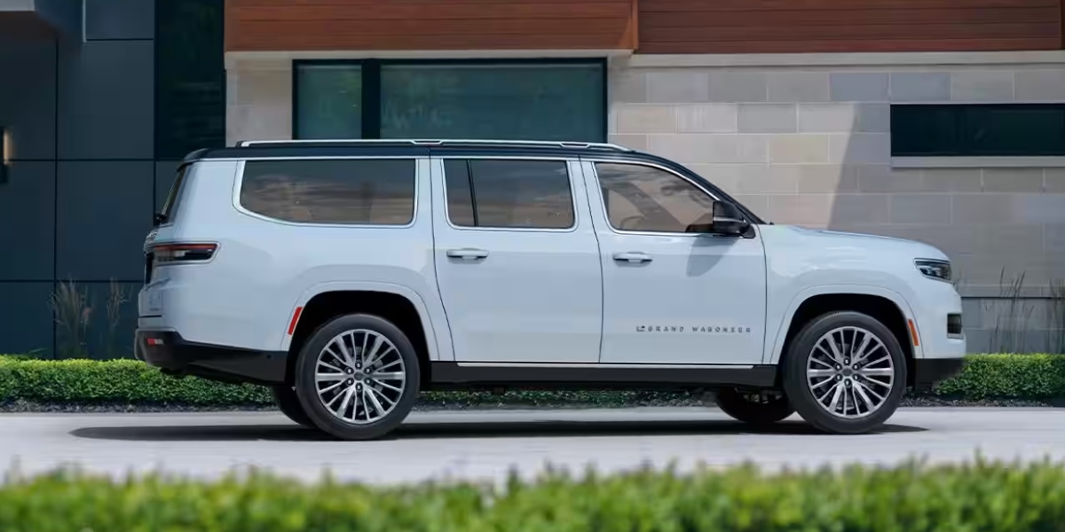 A white Jeep Grand Wagoneer full-size SUV is parked.