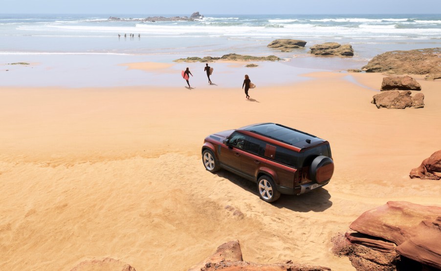 Crimson 2023 Land Rover Defender 130 parked at the beach