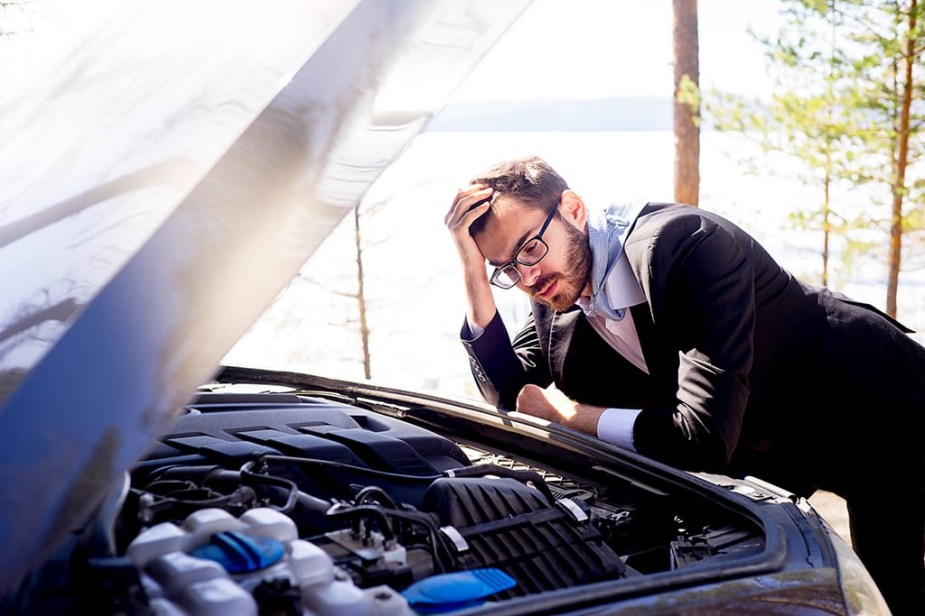 A man checking on his overheating engine