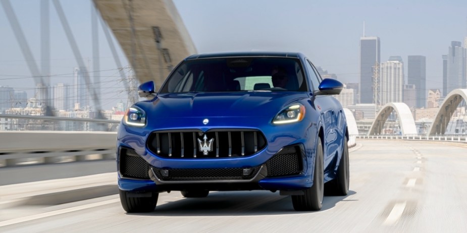 A blue 2023 Maserati Grecale small luxury SUV is driving on the road. 