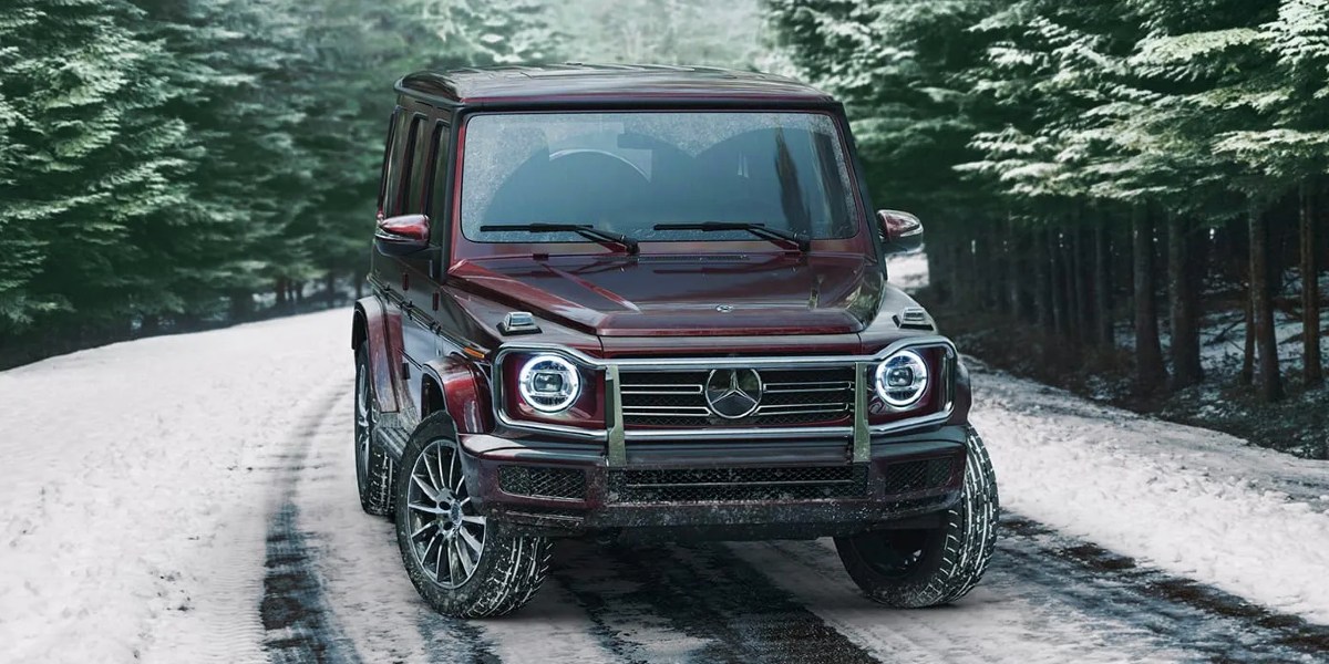 A burgundy 2023 Mercedes-Benz G-Class is parked on a snowy road.