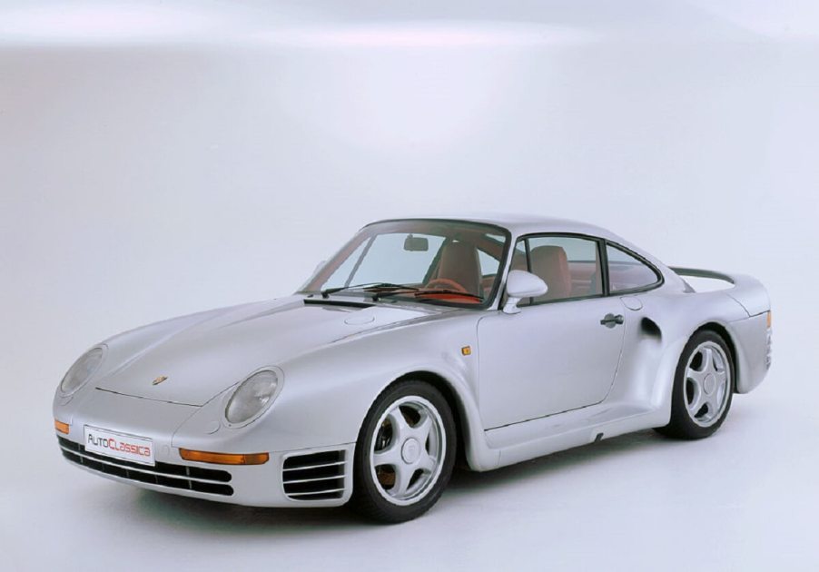 A silver 959 poses for a picture on a stage.