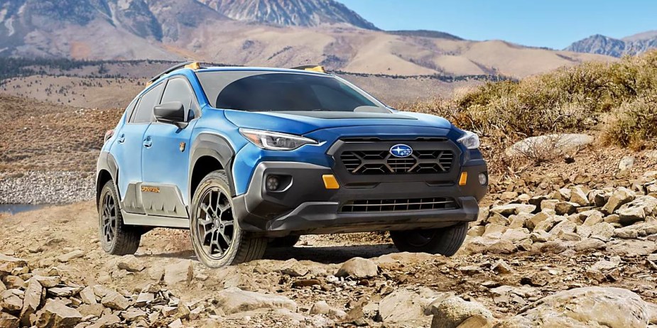 A blue 2024 Subaru Crosstrek Wilderness, an entry-level off-roader, is parked outdoors. 