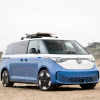 VW ID Buzz parked on the beach with a surfboard on the roof