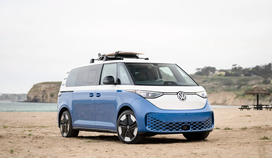 VW ID Buzz parked on the beach with a surfboard on the roof