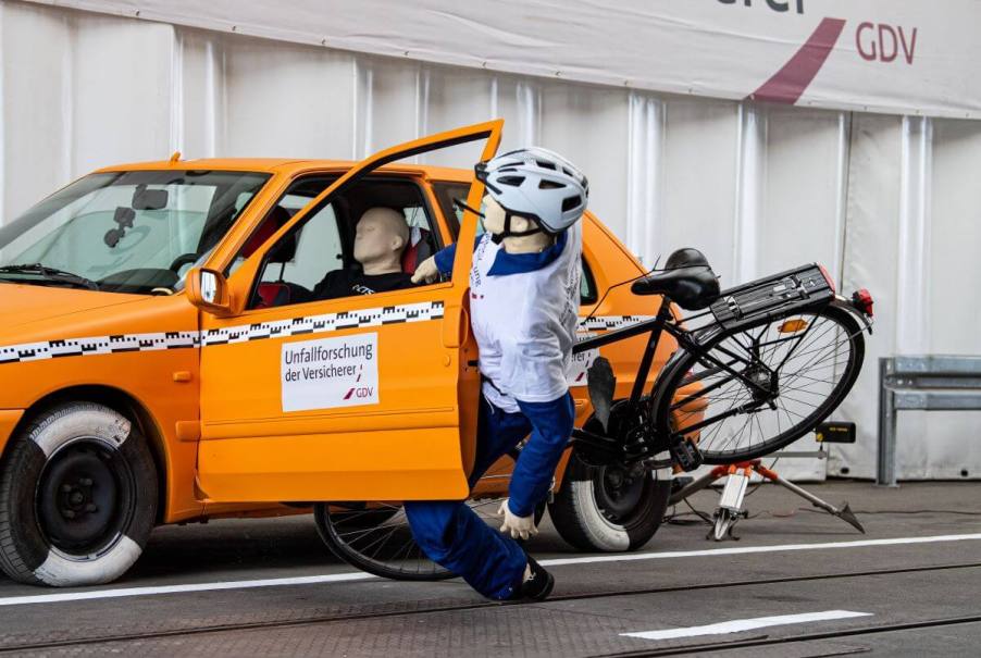 A crash safety test simulating a 'dooring' accident with a cyclist dummy