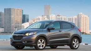 A gray 2017 Honda HR-V subcompact SUV model parked near water with a city skyline in the background