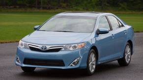 A blue 2012-2014 model year Toyota Camry midsize sedan model parked on asphalt