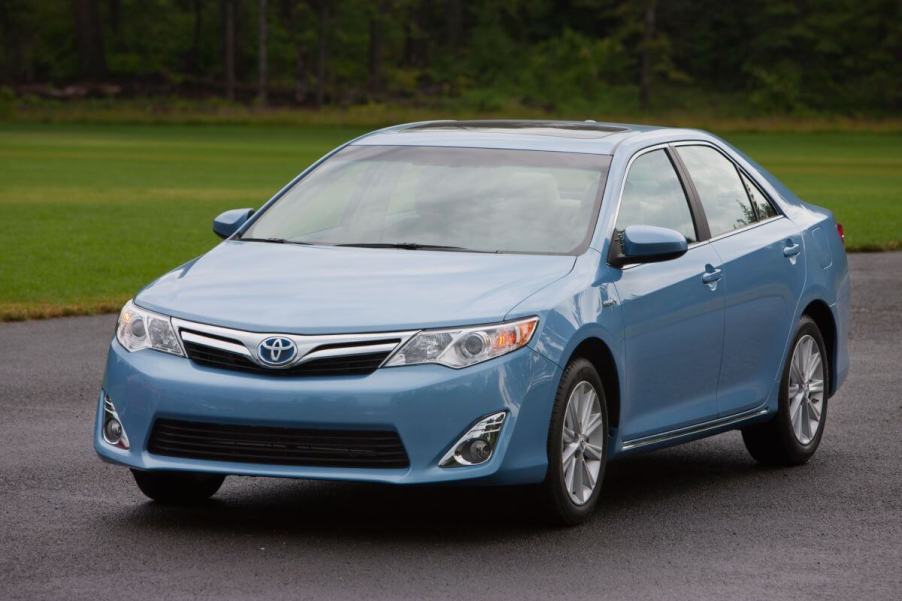 A blue 2012-2014 model year Toyota Camry midsize sedan model parked on asphalt